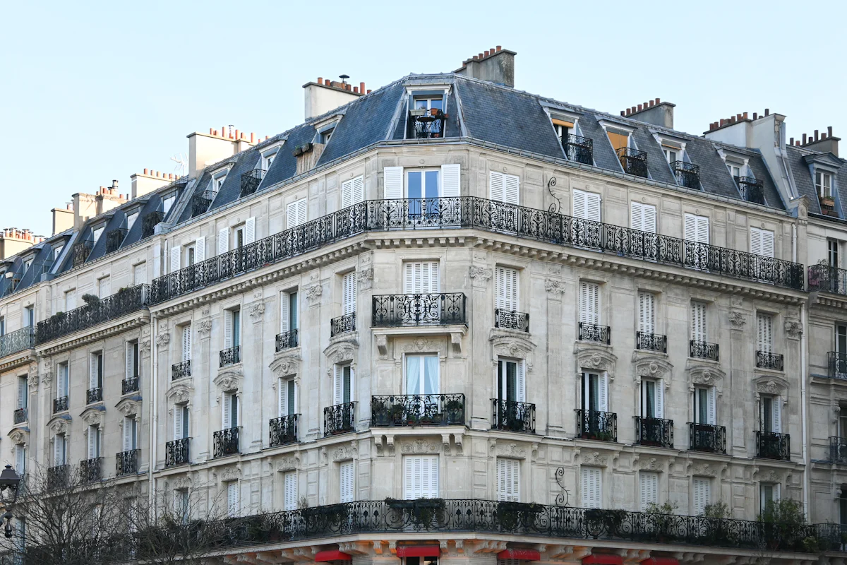 Immeuble haussmannien en pierre de taille avec balcons filants en fer forgé à Paris