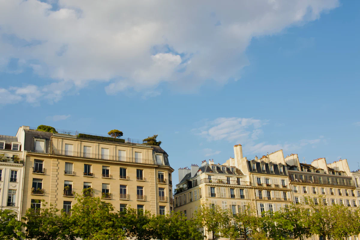 Façades d’immeubles haussmanniens en pierre claire sous un ciel bleu à Paris